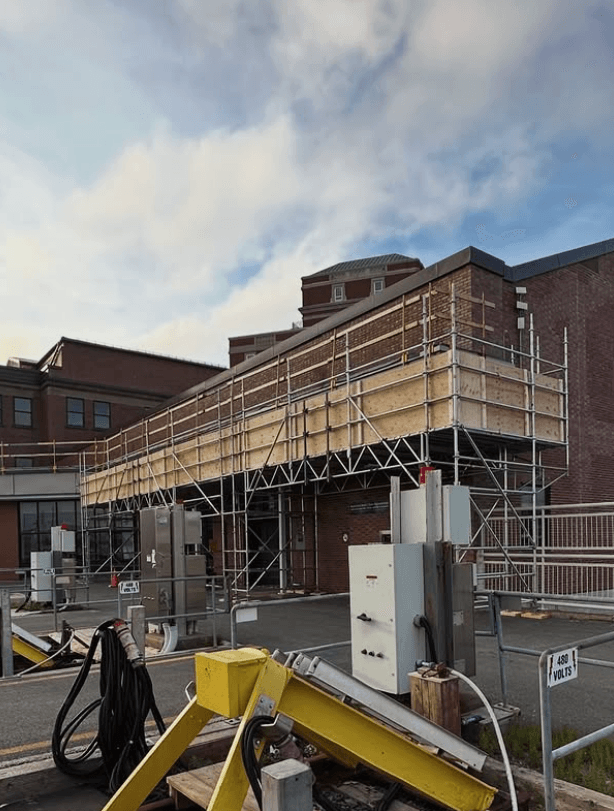 Overhead protection scaffold and sidewalk shed beside a building